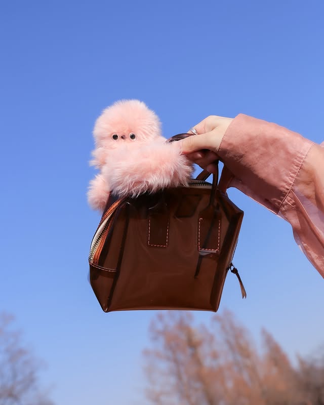 في ظل موجة الإكسسوارات التي تأتي لتزين الحقائب الرائجة خلال الآونة الأخيرة، يظهر اسم Mirumi في الواجهة لكن بتفاصيل تفاعلية أكثر من أي تصميم آخر.  ما هو Mirumi؟  Mirumi هو روبوت صغير، يمكن أن تضيفيه كإكسسوار على حقيبتك، يتفاعل مع الأصوات واللمس والحركة، ويلتفت بنظرات خجولة تخلق لحظات مفاجئة من الفرح. من خلال حركاته العفوية وتفاعله الطبيعي، يقدّم Mirumi تجربة مختلفة تقوم على الإحساس واللحظة، وليس على التعقيد أو الوظائف التقليدية. إكسسوار جميل بتفاصيل لافتة Mirumi يلاحظ العالم من حوله ويستدير لإلقاء نظرة. عندما تلتقي عيناه بعينيك، تشعر بلحظة من السعادة غير المتوقعة، مثل النظر المفاجئ لطفل صغير في مكان عام. ليس هذا فقط لك، بل يمكنه أن يجلب البهجة لمن حولك، فإذا كان مثبتاً على حقيبتك، قد يلتفت إلى شخص خلفك في القطار أو المكتب ويمنحه لحظة مفاجئة لطيفة. تفاعلاته الحية •	نظرات خجولة: يرمق من حوله وقد تلتقي عيناه بعينيك بشكل عفوي قبل أن ينظر بعيدًا، ليخلق لحظات صغيرة من الدفء. •	استجابة للمس: حساس في رأسه يكتشف التربيت، ويصدر ردود أفعال عشوائية وجذابة عبر خوارزمية خاصة. •	استجابة للأصوات: يدير رأسه باتجاه أي صوت أو صوت بشري، مظهراً الفضول والانتباه. •	حركة تلقائية: يتحرك أحياناً من تلقاء نفسه، مما يمنحه سلوك حي وطبيعي. تصميم ذكي وثابت صُمم Mirumi ليتمسك بإحكام بالحقائب، الأعمدة، أو أي أسطح ضيقة، ليبقى ثابتاً أثناء الحركة. يمكن وضعه على الحقيبة أو المكتب أو أي مكان آخر، وهو يظل يلفت الأنظار بسحره الصغير. رفيقك اليومي للبهجة Mirumi ليس مجرد لعبة أو ديكور، بل رفيق صغير يضيف لحظات فرح غير متوقعة في يومك. كل حركة، نظرة أو استجابة للمس تصنع تجربة لطيفة تشعر معها بالراحة والسرور.