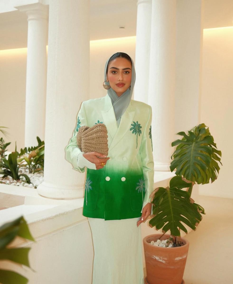 يارا النملة ترتدي البليزر الأخضر مع شجرة النخيل 