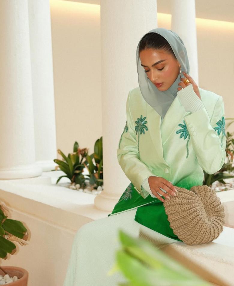 يارا النملة بالبليزر الأخضر بنقشة شجرة النخيل وحقيبة من القش 