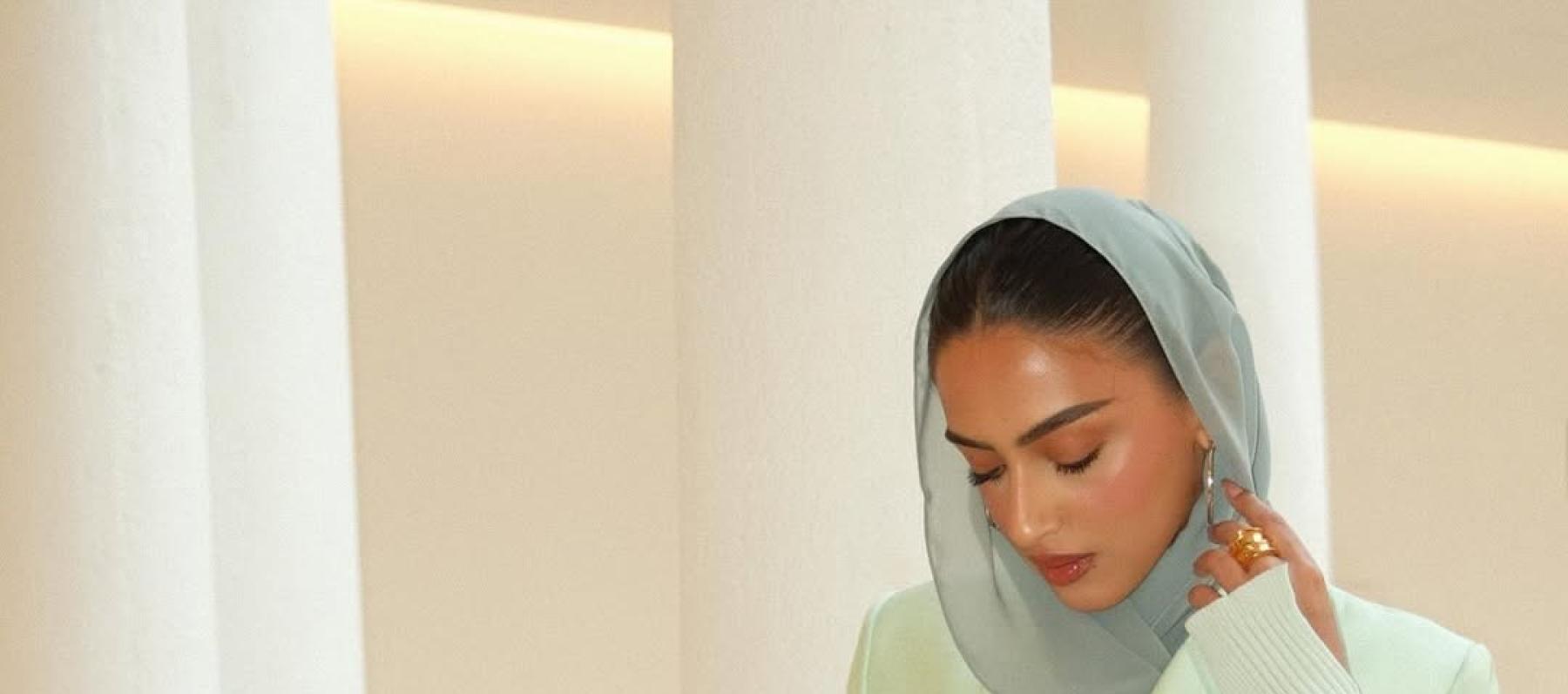 يارا النملة بالبليزر الأخضر بنقشة شجرة النخيل وحقيبة من القش 