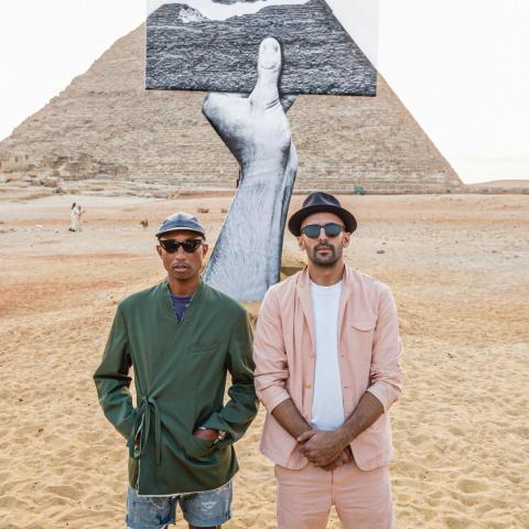 فاريل ويليامز وJR أمام الأهرامات خلال افتتاح معرض &quot;للأبد الآن&quot;- انستغرام @pharell