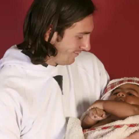 ميسي و هو يحمل  يامال بين يديه في عام 2007 - صورة بعدسة خوان مونفورت