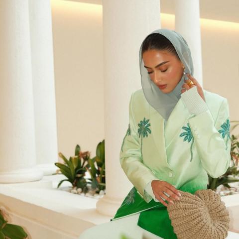 يارا النملة بالبليزر الأخضر بنقشة شجرة النخيل وحقيبة من القش